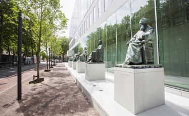 Het gebouw van de Hoge Raad aan het Korte Voorhout met daarvoor standbeelden van rechtsgeleerden
