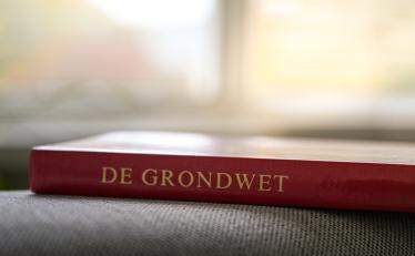 Boek met daarop de tekst "De grondwet"